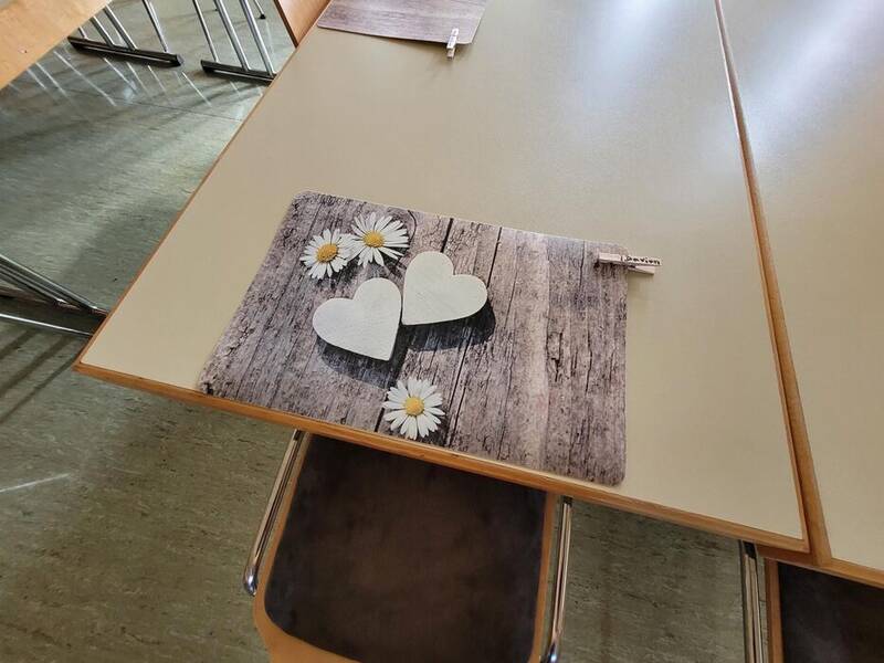 Ein Tisch mit einem Gedeck drauf, wo herzen zu sehen sind