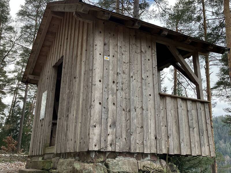 Die Welzberghütte scheint für Fuchsklingenwandernde über dem Hang zu balancieren. Pfosten unter der Front stützen sie nach Hirsau hin ab.