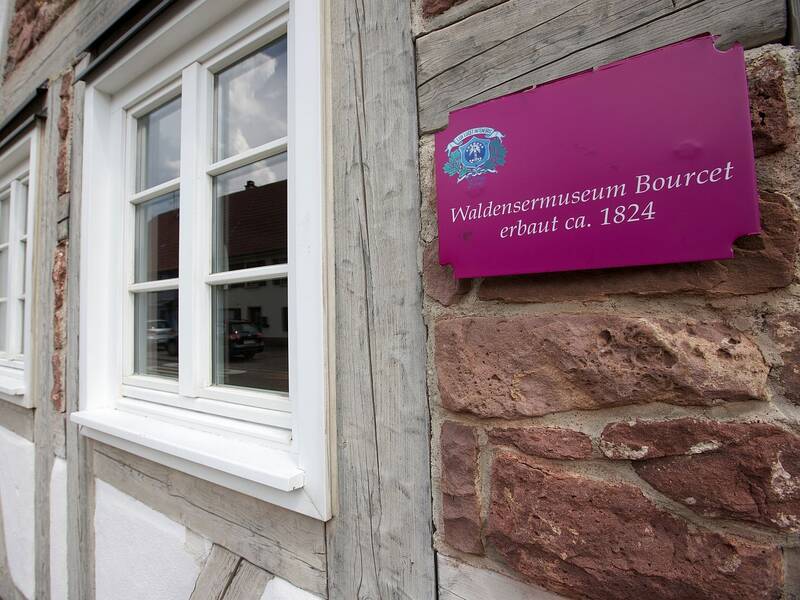 Ein pinkfarbenes Schild verrät, wann das Waldensermuseum entstanden ist.