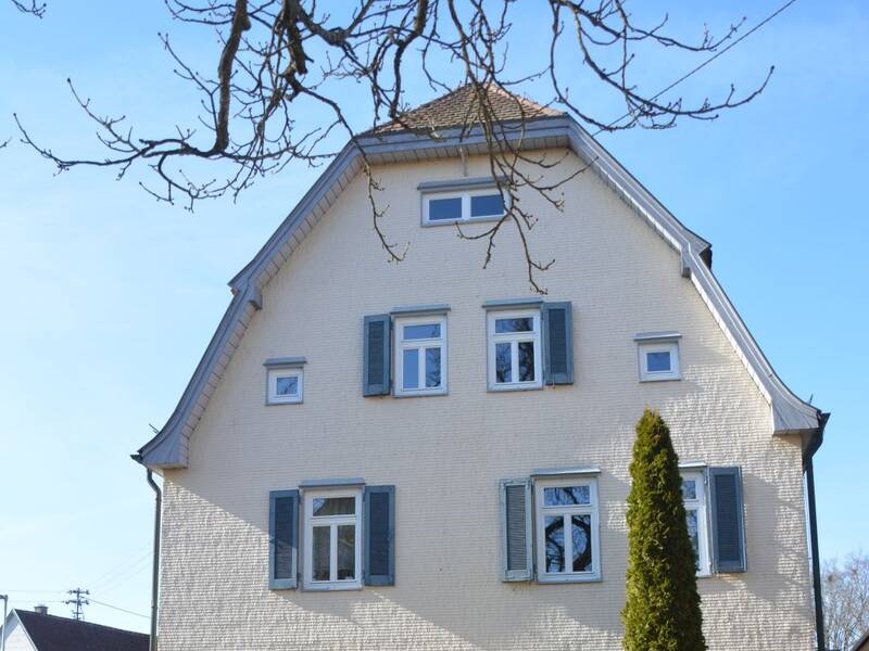 Gegenüber der Ortsverwaltung Neuhengstett steht das Alte Pfarrhaus mit seinen hellen Schindelwänden.