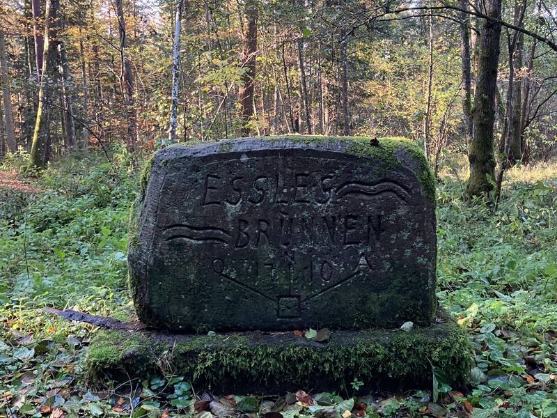 Ein gravierter aufrecht stehender Steinblock markiert den Standort des Esslesbrunnens, Zankapfel zwischen den Gemeinden.