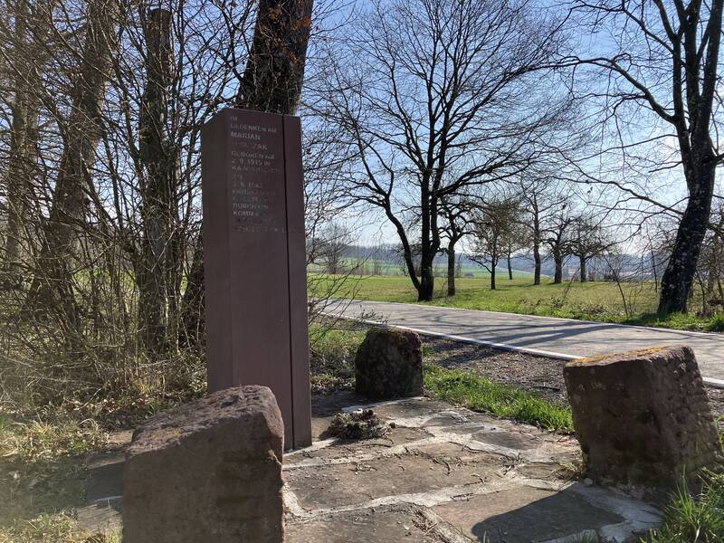 Die Stele aus rotem Buntsadnstein erinnert an die Ermordung des polnischen Zwangsarbeiters Marian Tomczak an dieser Stelle.