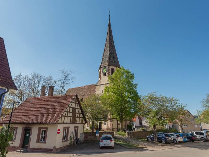 Der spitze Turm der Markuskirche ragt hinter dem Backhaus auf.
