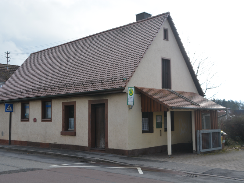 Vorne Bushaltestelle, hinten Vereinsheim der DLRG Neuhengstett, in der Mitte Backhaus