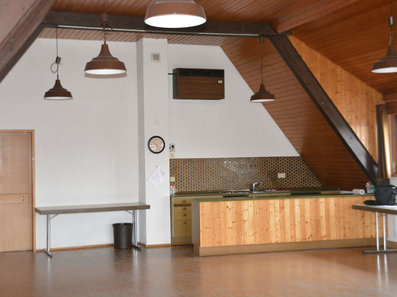 Blick durch den Saal zu Küche und Ausgang hin