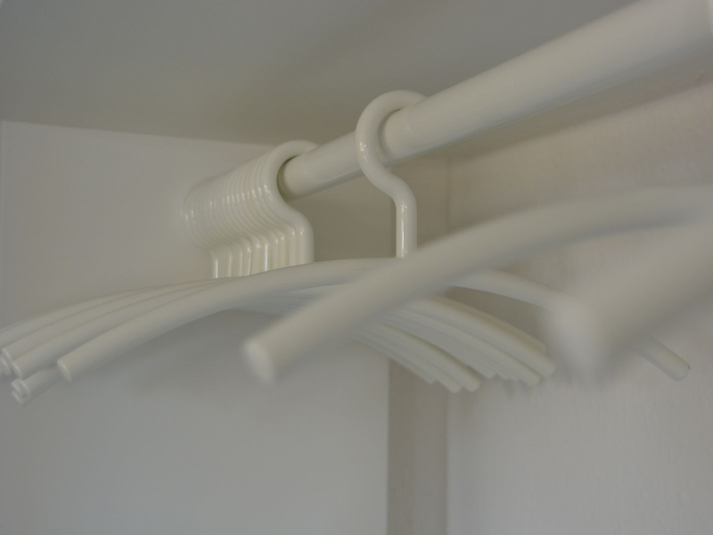 Bügel hängen in der kleinen Garderobe in einer Ecke des Besprechungsraums.